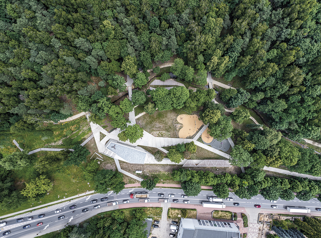 Widok z góry na polanę, splot betonowych alejek i pawilon w parku miejskim w Starachowicach
